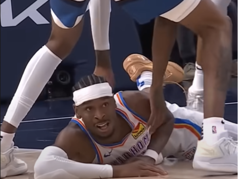 Shai Gilgeous-Alexander passes the ball between a defender’s legs while falling during Game 4 against the Timberwolves.